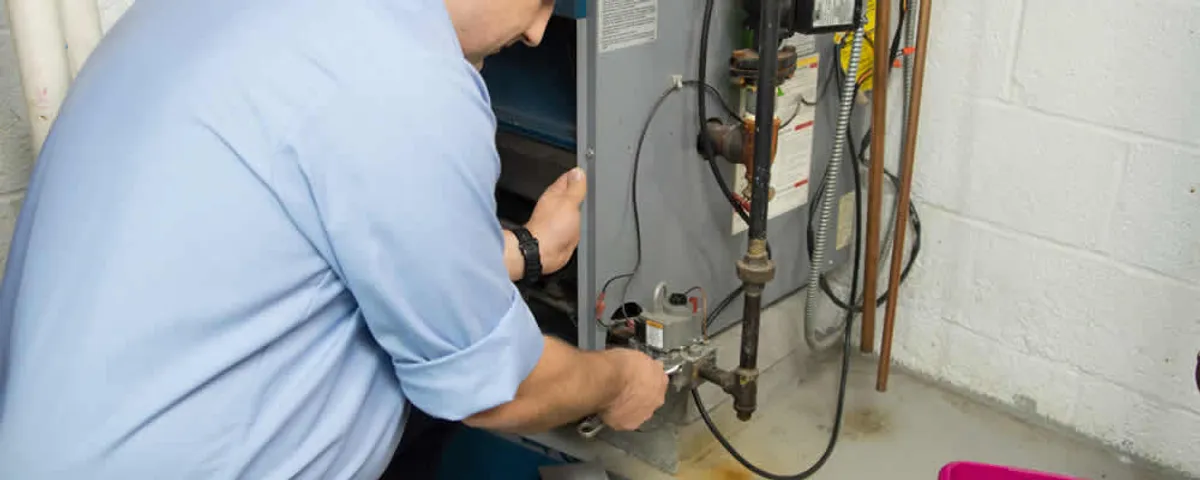 Furnace repair technician inspecting and servicing a home heating system in Tulsa, OK