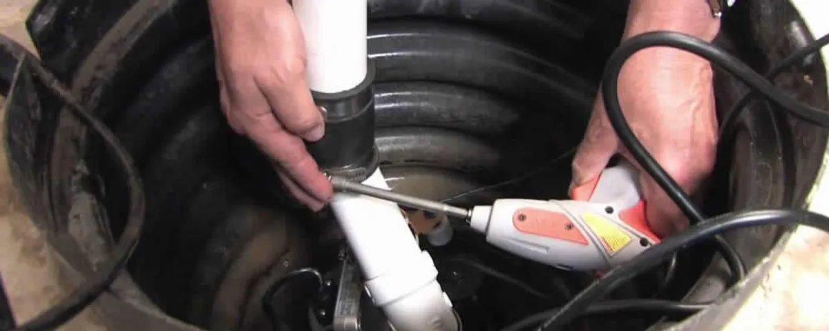 Sump pump installation technician connecting PVC discharge piping in Tulsa, OK